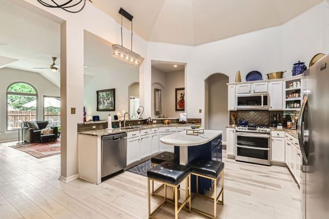 Kitchen with appliances with stainless steel finishes, arched walkways, lofted ceiling, a ceiling fan, and light wood-type flooring | Image 8