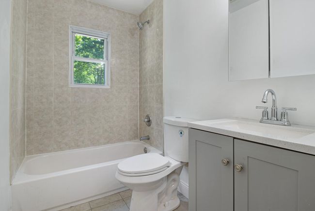 Full bath featuring toilet, vanity, shower combination, and tile patterned flooring | Image 19