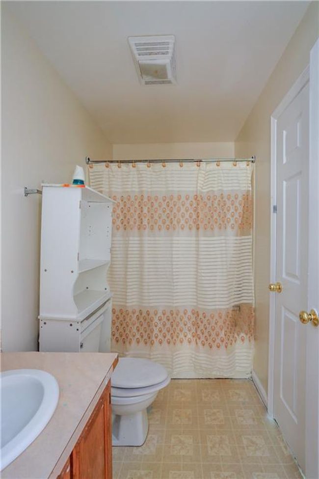 Bathroom featuring vanity, toilet, and a shower with curtain | Image 11