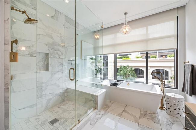 [Primary Bath] The spa like bath equipped with soaking tub, elegant pendant light and motorized shades | Image 23