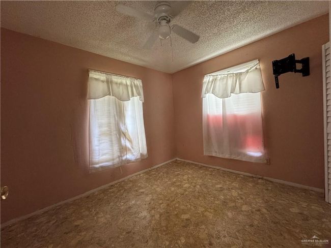 Carpeted spare room featuring a ceiling fan and a textured ceiling | Image 9