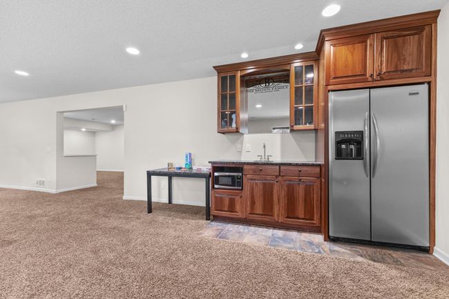 Lower level wet bar including an extra table for added counter space or use as a game table | Image 46