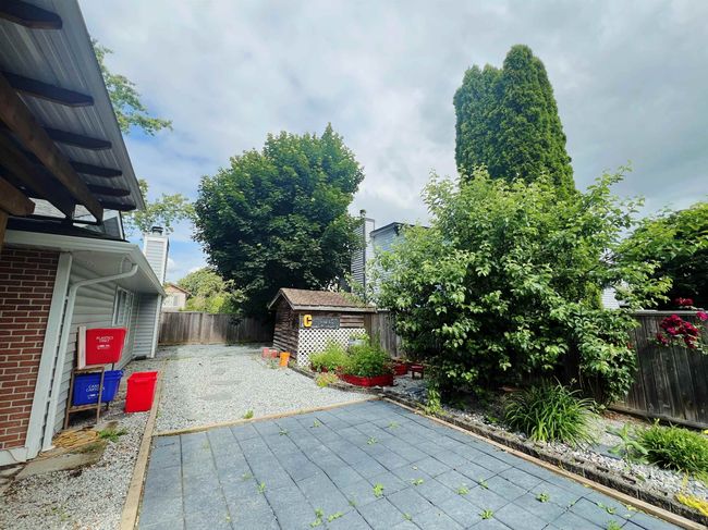 Fenced backyard featuring a storage unit, a patio area, and driveway | Image 15