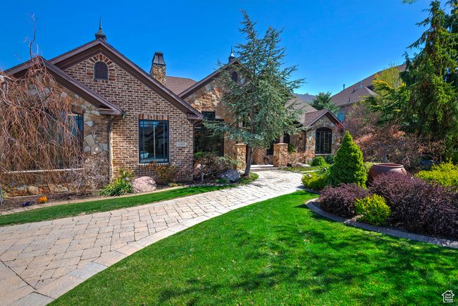 View of front of property featuring a chimney, stone siding, a front lawn, and brick siding | Image 67