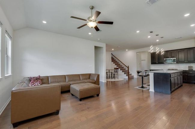 Living room featuring a ceiling fan, stairs, recessed lighting, wood finished floors, and baseboards | Image 15