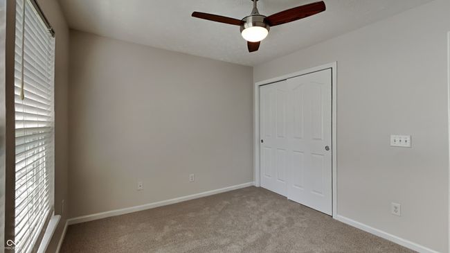 unfurnished bedroom featuring carpet, baseboards, a closet, and a ceiling fan | Image 15