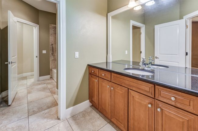 Full bathroom with a shower, tile patterned flooring, vanity, and baseboards | Image 20