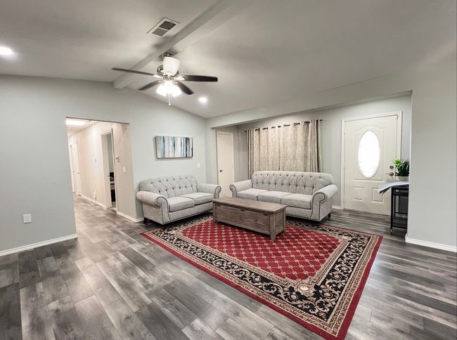 Living room with ceiling fan and wood finished floors | Image 4