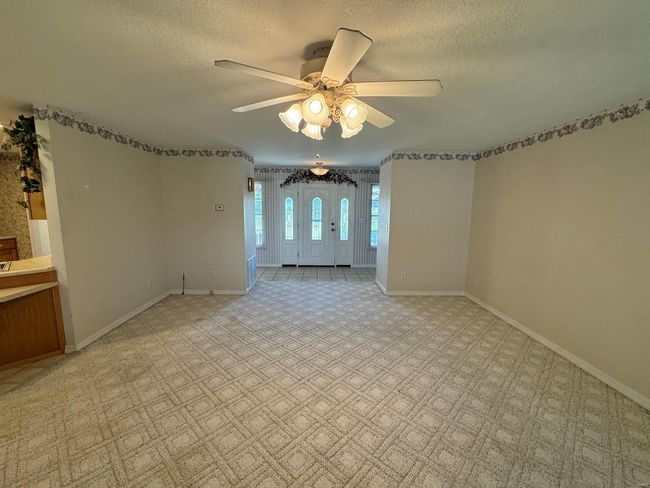 Carpeted spare room featuring ceiling fan and a textured ceiling | Image 17