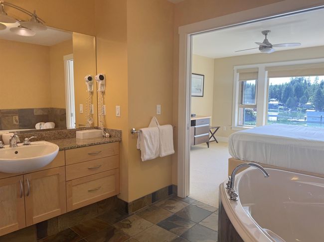 Bathroom with vanity, a garden tub, a ceiling fan, and stone finish floors | Image 24