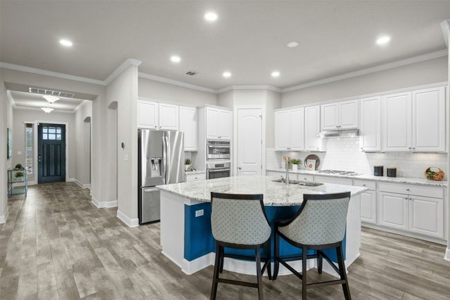 This gourmet kitchen features a large center island with a breakfast bar, providing additional seating and prep space. | Image 11