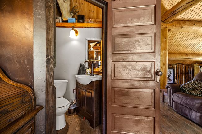 Half bath with hardwood / wood-style flooring, vanity, toilet, and wooden ceiling with exposed beams | Image 24