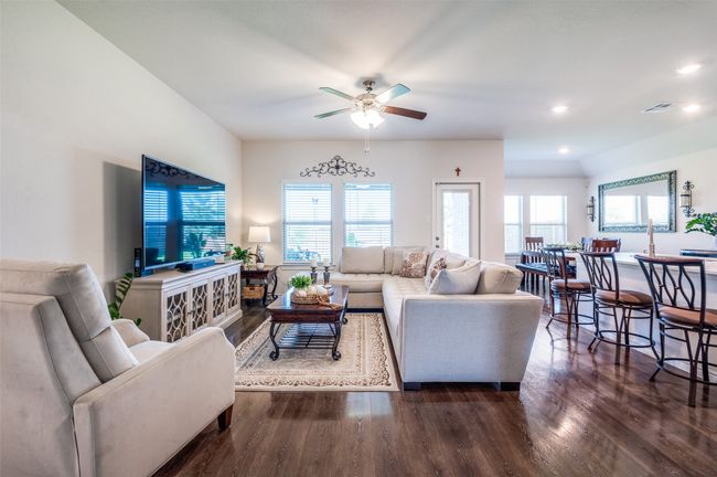 Living area featuring wood finished floors, a ceiling fan, and recessed lighting | Image 5