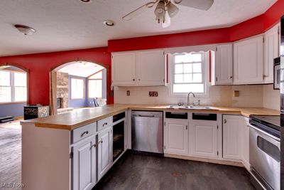 Kitchen featuring kitchen peninsula, stainless steel appliances, and white cabinets | Image 3