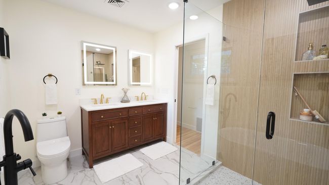The heart of the private owners suite is a calming, spa-like bathroom with amazing custom touches. The solid wood, double vanity comes equipped with quartz countertops, two sinks, gold hardware, generous storage, and LED touch vanity mirrors. | Image 4