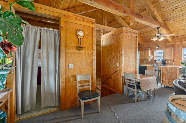 Interior space featuring lofted ceiling with beams, ceiling fan, wooden ceiling, and wood walls | Image 23