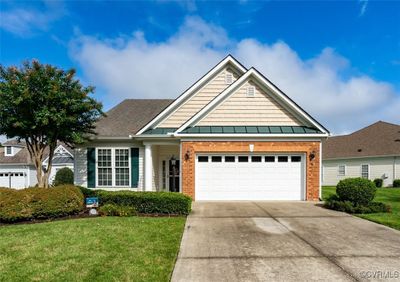 Craftsman-style house featuring a front lawn and a garage | Image 1