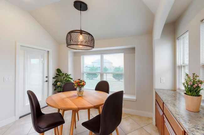 Dining room featuring lofted ceiling, light tile patterned flooring, and baseboards | Image 9