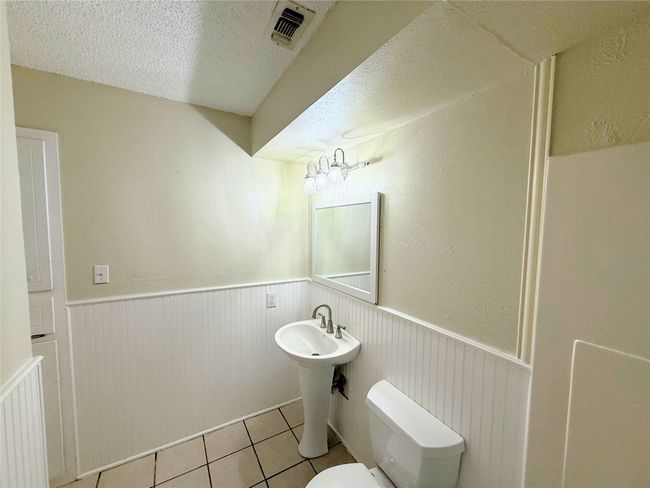 Bathroom featuring tile patterned floors, a wainscoted wall, and a textured ceiling | Image 22