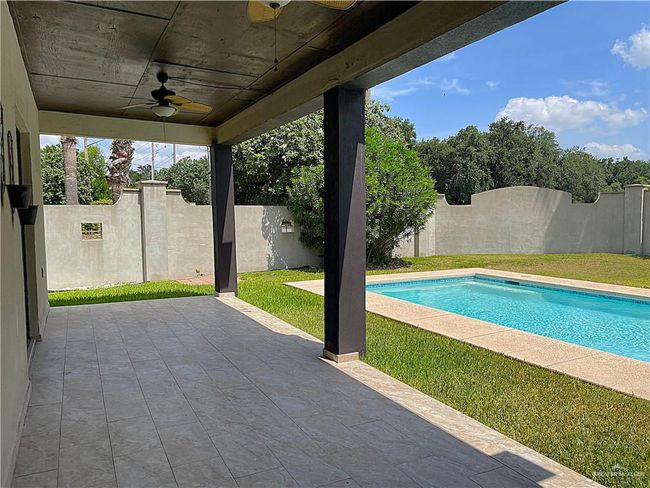 View of pool with ceiling fan, a fenced backyard, and a patio | Image 34