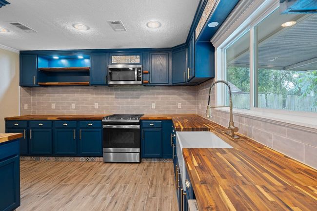 Kitchen with deep farm sink and view to private backyard. | Image 12
