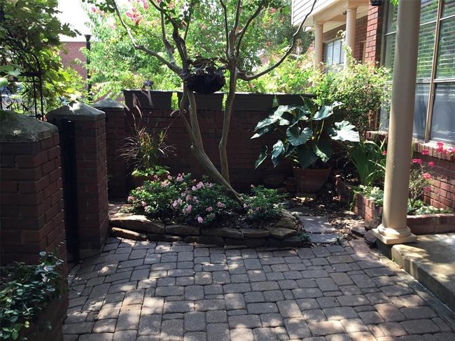 The private courtyard has much to offer, including a small flower bed, pavers, and a covered front stoop. | Image 10