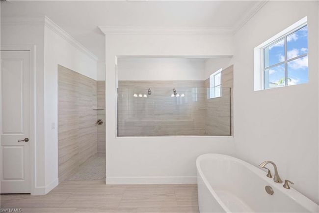 Full bath with baseboards, crown molding, a walk in shower, and a soaking tub | Image 16
