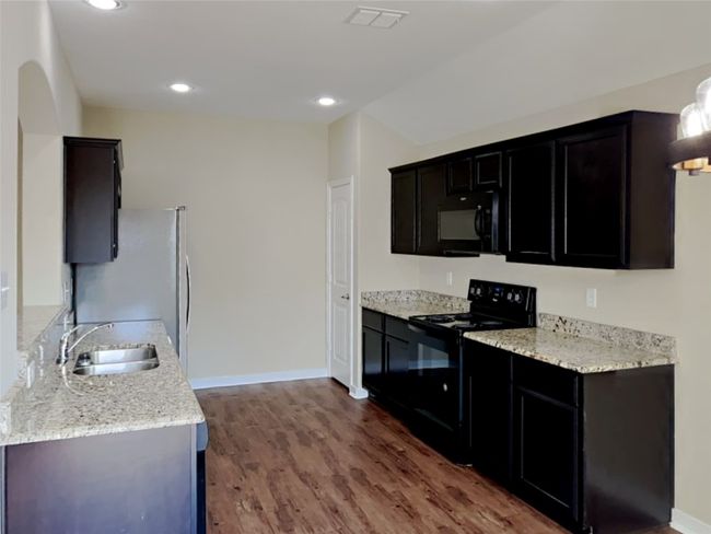 Kitchen featuring black appliances, wood finished floors, and recessed lighting | Image 10