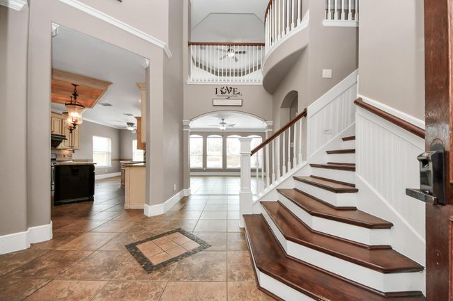 Stunning 2 story high ceiling entry with hard stained cherry solid oak floor steps. | Image 5