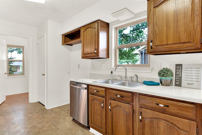 Kitchen featuring stainless steel dishwasher, brown cabinetry, and light countertops | Image 30
