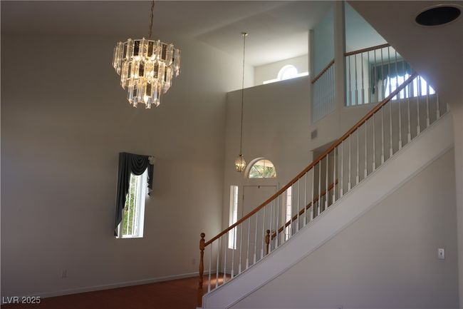 Stairway with a high ceiling, a chandelier, and wood finished floors | Image 17