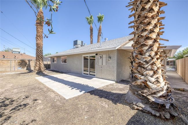 Rear view of property featuring stucco siding, a fenced backyard, and a patio area | Image 30