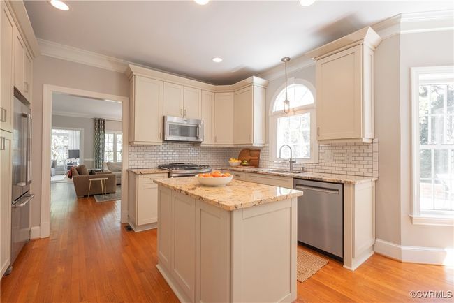 Kitchen with crown molding, a wealth of natural light, light wood-type flooring, a sink, and stainless steel appliances | Image 19