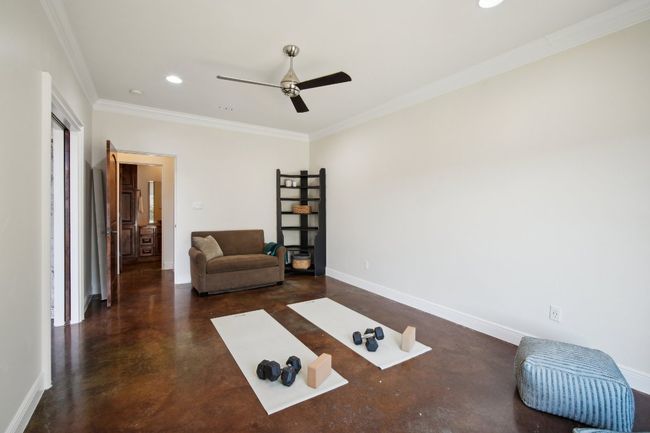 Living room featuring a ceiling fan, finished concrete flooring, recessed lighting, crown molding, and baseboards | Image 31