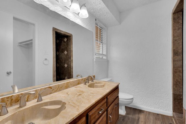 Bathroom with a sink, baseboards, toilet, and wood finished floors | Image 25