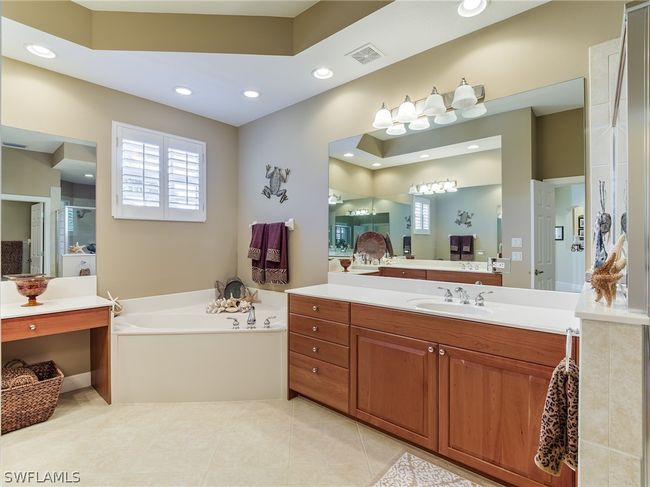 Bathroom with tile flooring, vanity, and a bath to relax in | Image 20