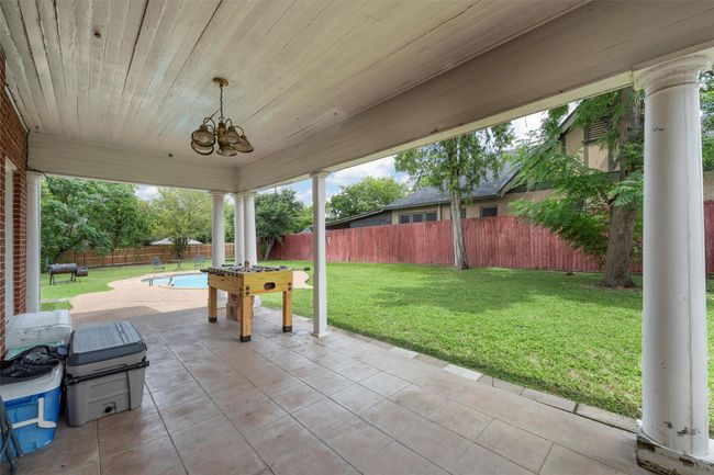 Fenced backyard with a patio area | Image 31