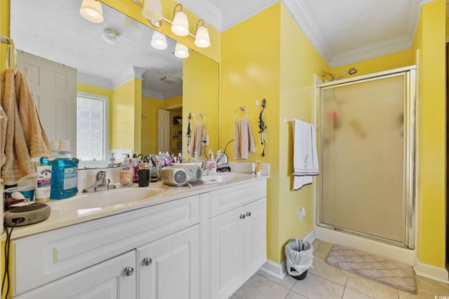 Full bath with a stall shower, double vanity, tile patterned floors, and ornamental molding | Image 11