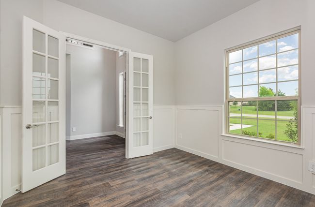 Spare room with french doors, dark wood-style floors, wainscoting, and a decorative wall | Image 18