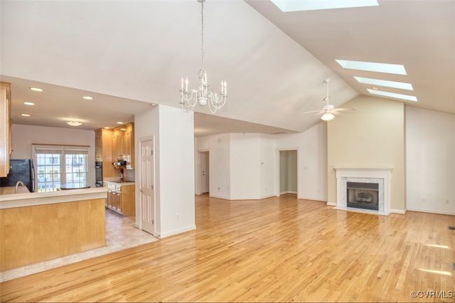 Unfurnished living room featuring light wood-type flooring, recessed lighting, a high end fireplace, and vaulted ceiling with skylight | Image 20