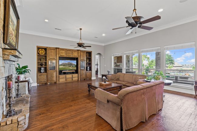 Living room with recessed lighting, a fireplace, a ceiling fan, visible vents, and arched walkways | Image 11
