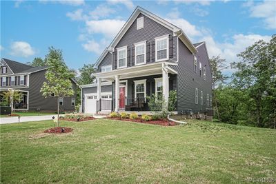 View of front facade with a front yard, a garage, and covered porch | Image 2