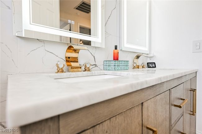 Interior details featuring decorative backsplash, a double sink, and visible vents | Image 45