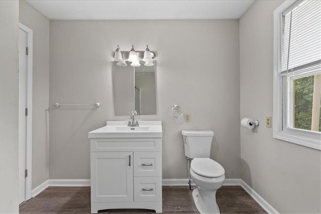 Bathroom featuring toilet, vanity, baseboards, and wood finished floors | Image 55