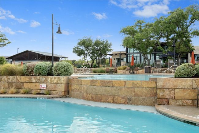 Amenity Center Pool for neighborhood has resort style Infinity-Edge, split level pool with large water fall, splash pad and water feature. Lots of room to spread out and play, or pull up a lounge chair and relax! | Image 29