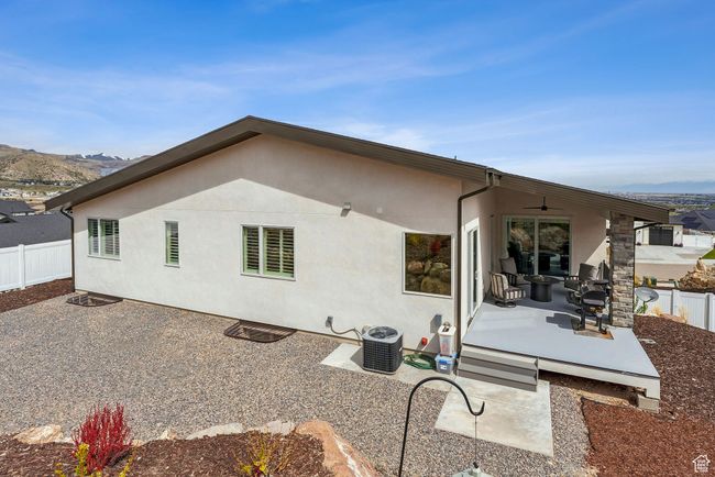 Rear view of house with a fenced backyard, stucco siding, a patio, a mountain view, and cooling unit | Image 64