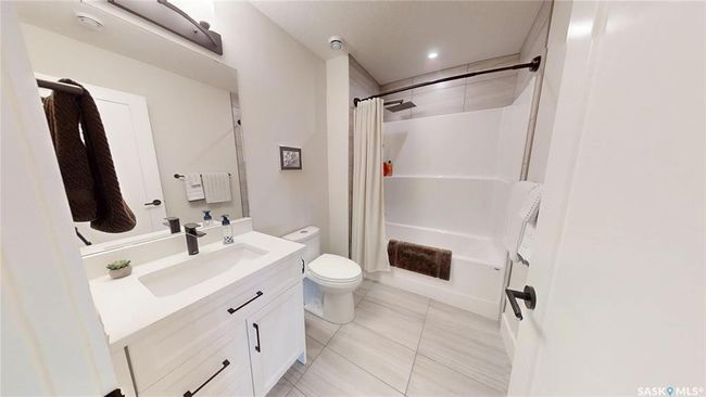 Bathroom featuring vanity, shower / bath combination with curtain, and tile patterned flooring | Image 32