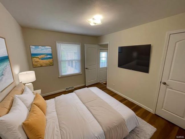 Bedroom featuring visible vents, baseboards, and dark wood finished floors | Image 11
