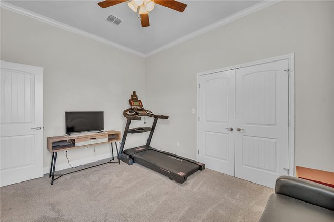 Workout room with carpet floors, ceiling fan, crown molding, and baseboards | Image 25