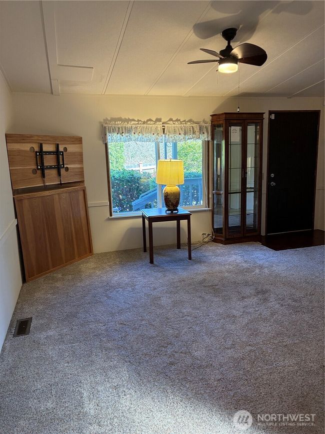 Living Room has Vaulted Ceiling with Fan + TV Rack in corner | Image 13
